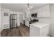 Modern kitchen with stainless steel appliances, white cabinets, and stylish flooring at 5532 Umatilla St, Denver, CO 80221