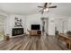 Open-concept living room with wood floors, a fireplace, and a ceiling fan at 5532 Umatilla St, Denver, CO 80221