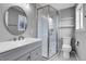 Updated bathroom with grey vanity, glass shower, and hexagon tile floor at 9359 W Lake Dr, Littleton, CO 80123