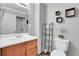 Clean bathroom with wood vanity, white toilet, and decorative accents at 9359 W Lake Dr, Littleton, CO 80123