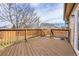 Wooden deck overlooks a fenced backyard with mature trees at 9359 W Lake Dr, Littleton, CO 80123