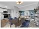 Modern dining room with dark wood table and blue chairs, open to the kitchen at 9359 W Lake Dr, Littleton, CO 80123