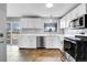 Updated kitchen featuring white cabinets, stainless steel appliances, and tile backsplash at 9359 W Lake Dr, Littleton, CO 80123