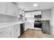 Modern white kitchen with stainless steel appliances and tile flooring at 9359 W Lake Dr, Littleton, CO 80123