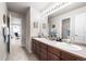 Double vanity bathroom with a view into an adjacent bedroom at 2834 S Fig St, Lakewood, CO 80228