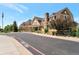 Exterior view of a lodge-like building with brown siding, a chimney, a dark road and green plants at 6988 S Riverwood Way, Aurora, CO 80016