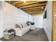 Partially finished basement features white walls, grey flooring and a comfortable sofa at 1607 Goldfield Trl, Castle Rock, CO 80109