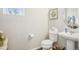 Charming powder room featuring a pedestal sink, toilet, and stylish decorative accents at 1607 Goldfield Trl, Castle Rock, CO 80109