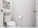 A half-bathroom with a toilet, toilet paper holder, and framed floral decorations on the wall at 1607 Goldfield Trl, Castle Rock, CO 80109
