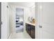 Modern bathroom featuring dark wood cabinetry, white countertops, and a glass-enclosed shower, leading into the primary bedroom at 1607 Goldfield Trl, Castle Rock, CO 80109