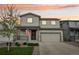 Charming two-story home featuring a covered porch, two-car garage, and well-maintained front yard with mature tree at 1607 Goldfield Trl, Castle Rock, CO 80109