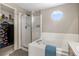 Bathroom featuring soaking tub with shower, octagon window, and adjacent closet with a safe at 957 Rosedale St, Castle Rock, CO 80104