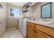 Functional laundry room with washer, dryer, sink, and storage shelves maximizes efficiency at 957 Rosedale St, Castle Rock, CO 80104