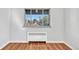 Bright bedroom featuring hardwood flooring, window with outside view and heater to keep cozy at 2100 N Franklin St # 15, Denver, CO 80205