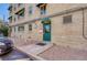 Rear entrance with green door, awnings, brick exterior, and parking area at 2100 N Franklin St # 15, Denver, CO 80205