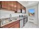 Well-lit kitchen with stainless steel appliances, granite counters, and white tile floors at 2100 N Franklin St # 15, Denver, CO 80205