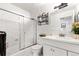 Traditional bathroom with tiled shower and tub, a white single sink vanity, and good lighting at 16673 E Kent Dr, Aurora, CO 80013