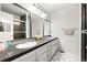 Clean bathroom featuring a double vanity with large mirrors, great lighting, and tiled floors at 16673 E Kent Dr, Aurora, CO 80013