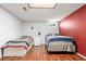 Basement bedroom with hard wood floors, two twin beds, and a mini fridge at 16673 E Kent Dr, Aurora, CO 80013