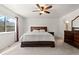 Cozy bedroom showcasing a large window, a ceiling fan, and a comfortable bed with quality linens at 16673 E Kent Dr, Aurora, CO 80013