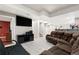 Basement living room featuring tiled floors, a large screen TV, and comfortable seating at 16673 E Kent Dr, Aurora, CO 80013
