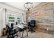 Well-lit home office featuring rustic wood accent wall, a chandelier, and two work stations at 16673 E Kent Dr, Aurora, CO 80013