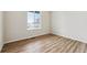 Bright bedroom featuring stylish wood flooring and a large window with views of the outdoors at 5918 Red Barn Ave, Mead, CO 80504