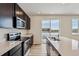 Modern kitchen featuring stainless steel appliances, an island, dark cabinets, and wood flooring at 5918 Red Barn Ave, Mead, CO 80504