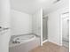Bathroom features a soaking tub, tiled surround, and walk-in shower at 10818 Cimarron St # 307, Firestone, CO 80504