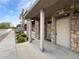 Charming townhome exterior featuring stone accents, covered entryway, and manicured landscaping at 10818 Cimarron St # 307, Firestone, CO 80504