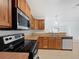 Well-lit kitchen with stainless steel appliances, oak cabinets and mosaic tile backsplash at 10818 Cimarron St # 307, Firestone, CO 80504
