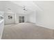 Bright, open living room featuring neutral carpet, ceiling fan, and sliding glass doors to a balcony at 10818 Cimarron St # 307, Firestone, CO 80504