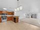 Combined kitchen and living area with stainless steel appliances, pendant lighting, and open layout at 10818 Cimarron St # 307, Firestone, CO 80504