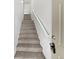 Carpeted staircase with white railing leading to the upper level at 10818 Cimarron St # 307, Firestone, CO 80504