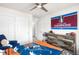 Sports-themed bedroom with ceiling fan, dresser, and a fun, colorful bedspread at 883 Widgeon Cir, Longmont, CO 80503