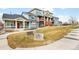 Well-maintained exterior of townhome with blue siding, steps, a red front door, and landscaped front yard at 883 Widgeon Cir, Longmont, CO 80503