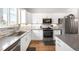 Bright kitchen featuring stainless steel appliances, modern countertops, ample cabinet space, and hardwood flooring at 883 Widgeon Cir, Longmont, CO 80503
