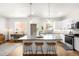 Modern kitchen features a large center island with barstool seating, sleek cabinets, and stainless appliances at 883 Widgeon Cir, Longmont, CO 80503