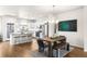 Open-concept kitchen and dining area features stainless steel appliances, white cabinets, and wood flooring at 883 Widgeon Cir, Longmont, CO 80503