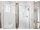Bright shower with glass door, white tile, black and gray accent tiles, and convenient built-in shelving at 883 Widgeon Cir, Longmont, CO 80503