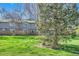 Well-maintained backyard showcases the home with a lawn, wooden fence, and lovely mature trees at 3850 Paseo Del Prado # 29, Boulder, CO 80301