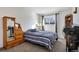 Neat bedroom featuring a comfortable bed, desk, and natural light from a window at 1235 S Monaco Pkwy, Denver, CO 80224