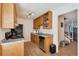 Galley kitchen featuring wooden cabinets, stainless steel appliances and view of staircase at 1235 S Monaco Pkwy, Denver, CO 80224