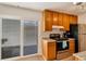 Compact kitchen featuring granite countertops, wood cabinets, and a sliding glass door at 1235 S Monaco Pkwy, Denver, CO 80224