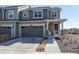 Charming two-story home with gray siding, attached garage, and welcoming front porch at 9501 Richfield St, Commerce City, CO 80022