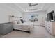 Bright main bedroom boasts tray ceiling, large window, and elegant light wood furnishings at 9501 Richfield St, Commerce City, CO 80022