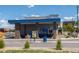 Exterior view of Dutch Bros with blue accents, a drive-thru, and signage at 9501 Richfield St, Commerce City, CO 80022