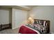 This bedroom has carpet, neutral walls, a bed with a floral comforter, and sliding door closet at 2033 E 167Th Way, Thornton, CO 80602
