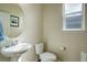 A half bathroom featuring a pedestal sink, a toilet and a window at 2033 E 167Th Way, Thornton, CO 80602