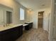 Primary bathroom featuring double sinks, dark cabinetry, and a walk-in shower at 737 Raindance St, Erie, CO 80516